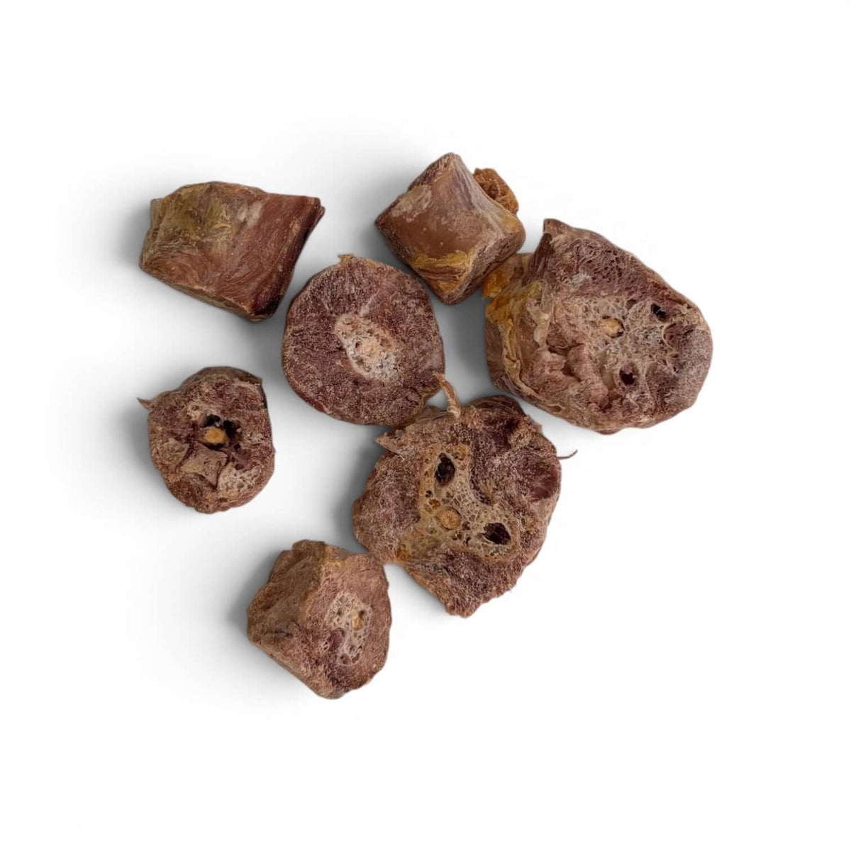 Pieces of Carnevere Mountain freeze dried turkey neck medallions dog treats on a white background