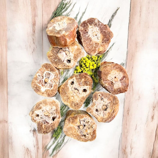 Turkey neck medallion dog treats on top of green garnish with yellow flowers